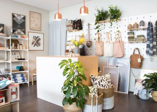 shop front with plants and bags.