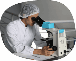 man in a white lab coat looking into a magnifying glass.