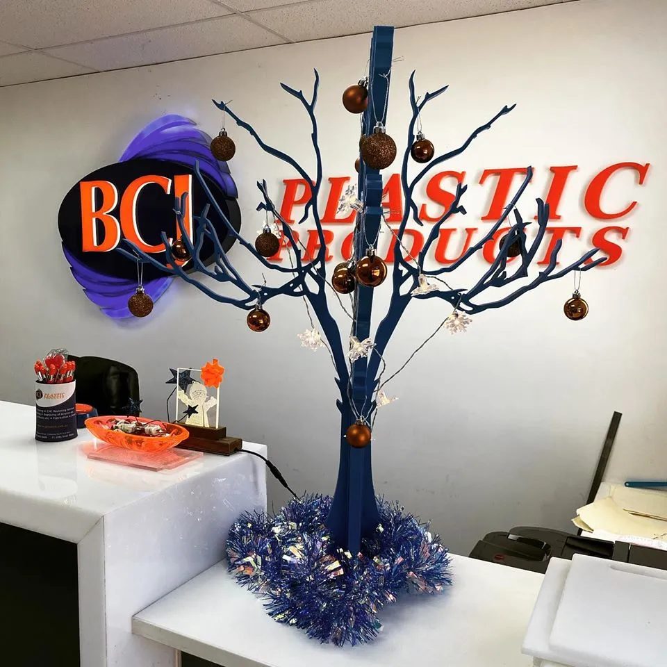 a decorated tree in an office cubicle with orange and blue decorations.
