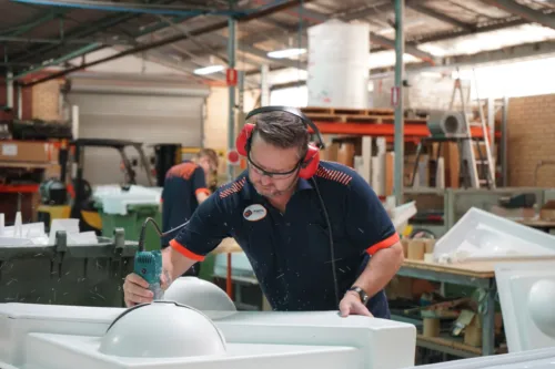 a man in a factory working on a machine.