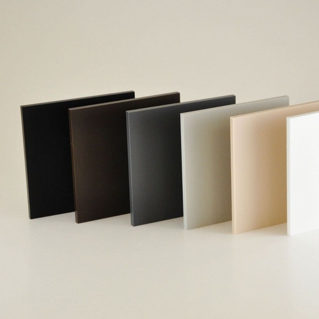 A row of different colored Perspex® Naturals sheets on a white surface.