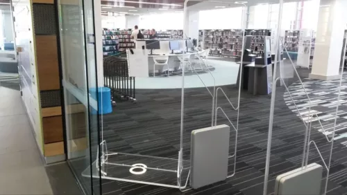 a library filled with lots of books and furniture.