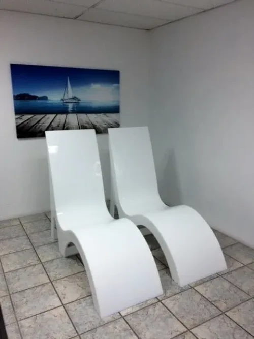 a couple of white chairs sitting on top of a tiled floor.