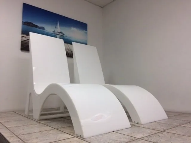 a couple of white chairs sitting on top of a tiled floor.
