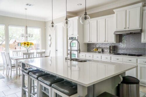 a large kitchen with a center island with stools.