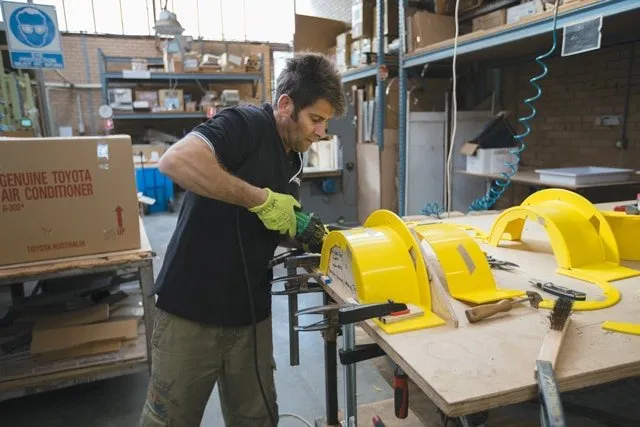 Worker moulding yellow plastic at BCJ Plastic Products